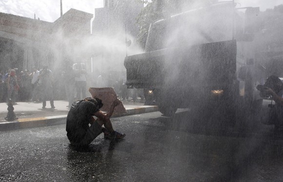 Turkish riot police use water cannon to disperse demonstrators during a protest against the destruction of trees in a park brought about by a pedestrian project, in Taksim Square in central